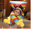 A young girl is hugging a large rainbow-colored plush toy. Produktbild-Vorschau