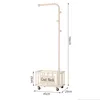 A cream-colored coat rack with a storage basket and wheels, shown with dimensions. Produktbild-Vorschau