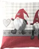 Close-up of a decorative pillow with gnome figures and a plaid pattern. Produktbild-Vorschau
