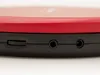 A close-up view of the side of a red and black portable CD player, showing the volume dial and ports. Produktbild-Vorschau