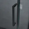 A close-up of a black shower door handle against a textured gray wall. Produktbild-Vorschau