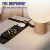 A wireless charging pad with a phone, earbuds, and a smartwatch charging on it, next to a lamp on a nightstand. Produktbild-Vorschau