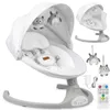 A white and gray electric baby bouncer with hanging toys, a canopy, and accessories like a remote control and power adapter, presented on a white background. Anteprima dell’immagine prodotto