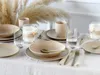 A table setting with plates, bowls, mugs, and glasses, decorated with dried pampas grass. Produktbild-Vorschau