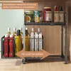 A two-tier kitchen cabinet organizer with various bottles and cans stored on it. The organizer is shown inside a cabinet. Produktbild-Vorschau