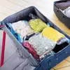 An open suitcase filled with vacuum-sealed bags of clothing. Podgląd zdjęcia produktu