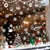 A decorated window with Christmas-themed stickers, including snowflakes, Santa's sleigh, and a Christmas tree. Produktbild-Vorschau
