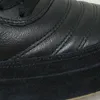 A close-up view of a black shoe, showing the texture of the leather and suede materials, and stitching details. Náhled obrázku produktu