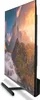A side view of a large flat-screen television on a black stand, displaying a vibrant landscape image. Produktbild-Vorschau