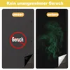 A split image comparing two window coverings. The left side shows a dark gray fabric with a red circle and slash over the word 'Geruch' (smell), indicating no odor. The right side shows a black background with green smoke-like wisps, representing an odor f Produktbild-Vorschau