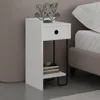 A white nightstand with a drawer and a shelf, next to a bed. Podgląd zdjęcia produktu