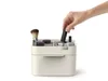 A hand is placing a lipstick into a makeup organizer. Náhled obrázku produktu