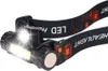 A close-up of a black LED headlamp with the strap visible. Produktbild-Vorschau