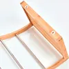 Close-up view of the back of a wooden towel rack with metal bars. Náhled obrázku produktu