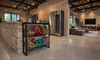 A modern industrial-style open-plan living and kitchen area with a beverage crate rack in the foreground. Produktbild-Vorschau