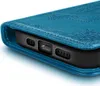 A close-up view of a blue phone case with embossed patterns, showing the bottom edge of a phone inserted into it. Podgląd zdjęcia produktu