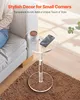 A clear acrylic side table with a coffee cup and a smartphone on it, placed next to a sofa on a brown rug. Podgląd zdjęcia produktu