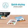 A printer is shown printing photos, with several printed photos on a wooden surface. Anteprima dell’immagine prodotto