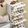 A white shoe cabinet with multiple shelves filled with shoes, placed next to a cushioned bench and a wall with a coat rack. Produktbild-Vorschau