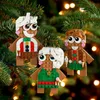 Three gingerbread man ornaments hanging on a Christmas tree with blurred lights in the background. Produktbild-Vorschau