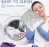 A woman is holding a pet bed in front of a washing machine with more pet beds inside. Produktbild-Vorschau