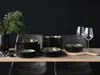 A table setting with a set of dishes, wine glasses, and a vase with greenery. Náhľad obrázku produktu