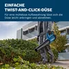 A person is holding a blue leaf blower in front of a hedge and a modern building. Produktbild-Vorschau