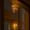 Two star-shaped lights hang from a string, illuminated by warm white LEDs. Voir les images du produit