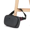 A dark gray sling bag with a black strap is attached to a wooden stool. Anteprima dell’immagine prodotto