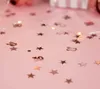 Confetti shaped like stars and the number 30, scattered on a pink surface with fairy lights. Produktbild-Vorschau