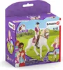 The image shows the packaging for a Schleich Horse Club toy set, featuring figures of a girl riding a horse and other girls. The background depicts a grassy field under a blue sky. Náhľad obrázku produktu
