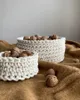 Two crocheted baskets filled with walnuts sit on a brown textured blanket. Podgląd zdjęcia produktu
