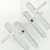 Two white door handles with locks are arranged diagonally on a light background. Náhled obrázku produktu