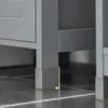 A close-up view of the bottom corner of a gray cabinet, showing its legs with clear protective caps on a tiled floor. Produktbild-Vorschau