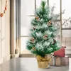 A small, decorated Christmas tree sits on a table next to wrapped gifts, with a window in the background. Náhled obrázku produktu