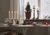 A festive table setting with candles and Christmas tree decorations. Produktbild-Vorschau