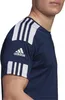 Close-up of a person wearing a navy blue Adidas t-shirt with white stripes on the sleeve and shoulder. Voir les images du produit