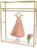 A gold garment rack with a peach dress, silver heels, and tulips on a white shelf. Podgląd zdjęcia produktu