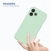 A hand holding a light green phone case against a white background. Produktbild-Vorschau