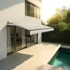 A modern house with a retractable awning extended over a patio next to a swimming pool. Produktbild-Vorschau