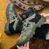 A pair of hiking boots are displayed on a yellow surface with a rusty metal background. Produktbild-Vorschau