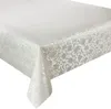 A white tablecloth with a floral pattern is draped over a table. Produktbild-Vorschau