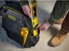 A person is placing a level into a tool bag. Voir les images du produit