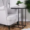 A black side table with a small potted plant on it, placed next to a light gray armchair. Podgląd zdjęcia produktu