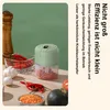 A mini food chopper is shown on a wooden table with ingredients like chili peppers and garlic. Produktbild-Vorschau