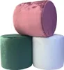Three round velvet ottomans stacked on top of each other against a white background. Produktbild-Vorschau