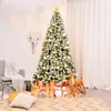 A decorated Christmas tree with presents and festive decorations in a room. Anteprima dell’immagine prodotto