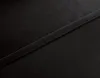 A close-up view of black fabric with a seam running diagonally across it. Produktbild-Vorschau