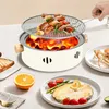 A portable charcoal grill with food being cooked on it, placed on a table with other food items. Anteprima dell’immagine prodotto