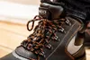 Close-up of a black winter work boot with orange and black laces. Náhľad obrázku produktu